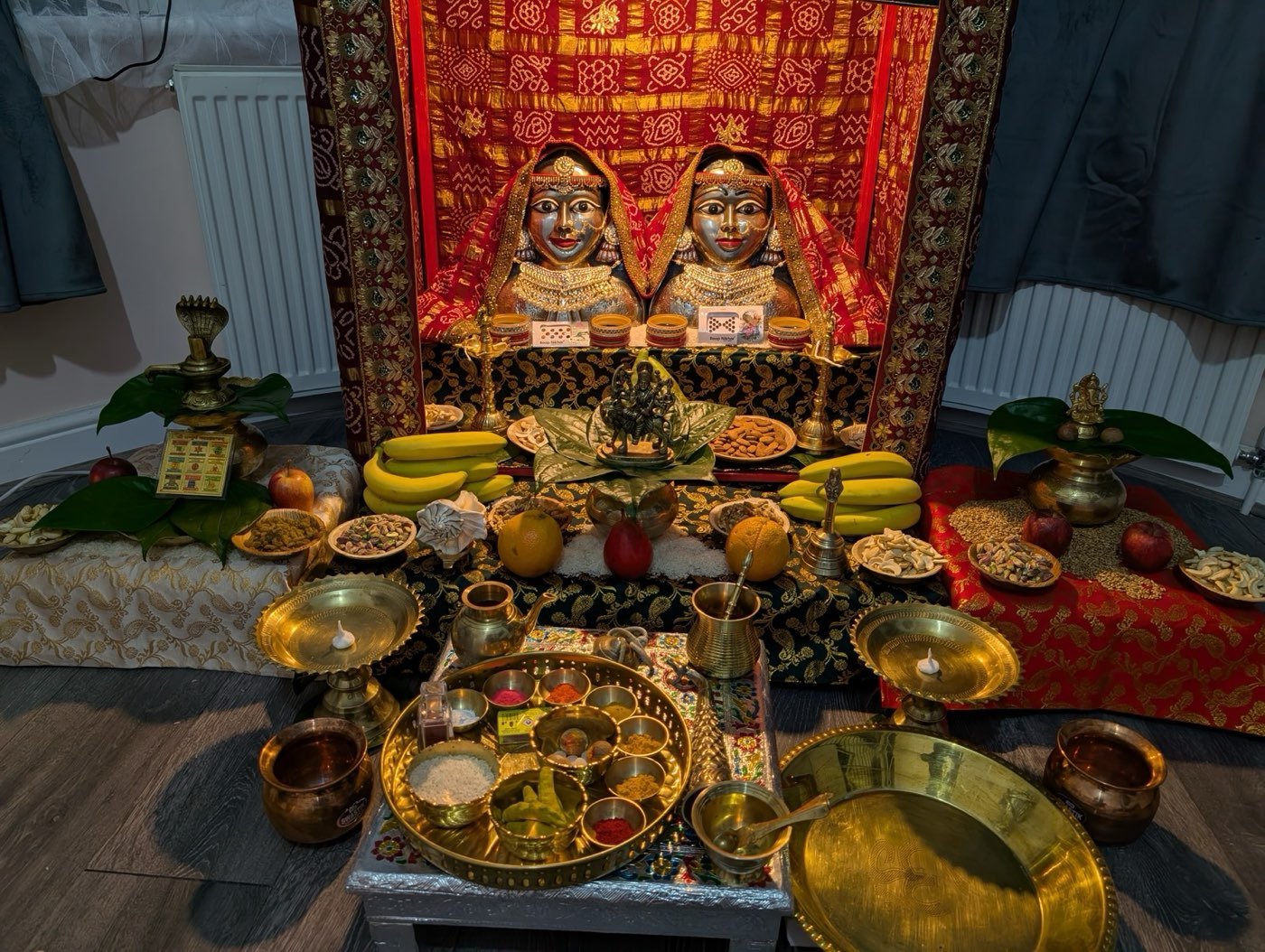 Evening puja altar with brass lamps and framed deities