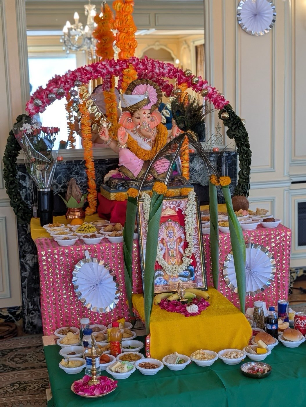 Ganesh murti in a decorated altar with flowers and offerings