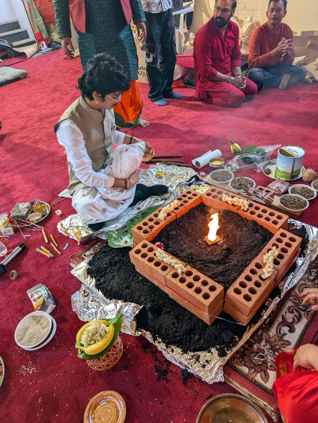 Parth Bhatt making offerings into a brick havan kund with the fire lit