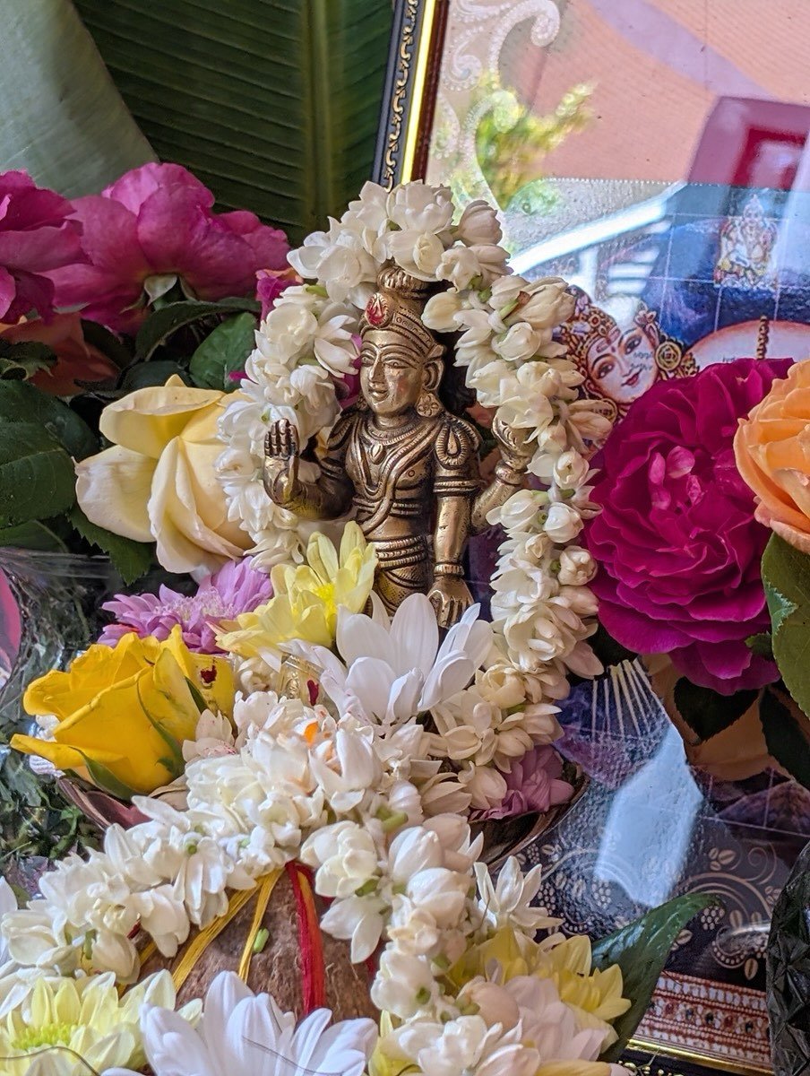 Brass murti garlanded with white jasmine and roses