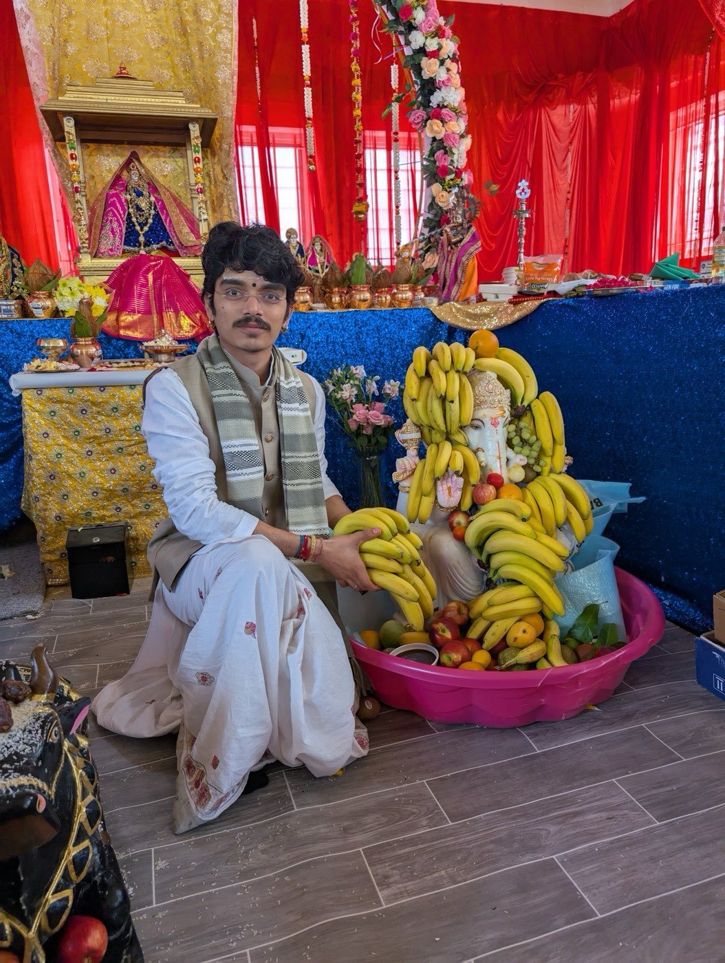 Parth Bhatt seated beside an altar decorated with bananas and flowers