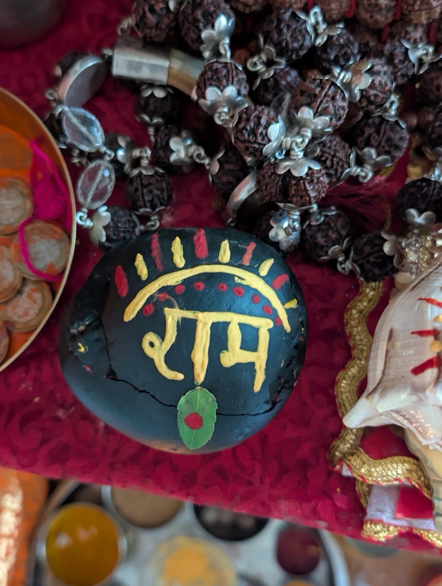 Painted stone with the name Ram in Devanagari, surrounded by rudraksha