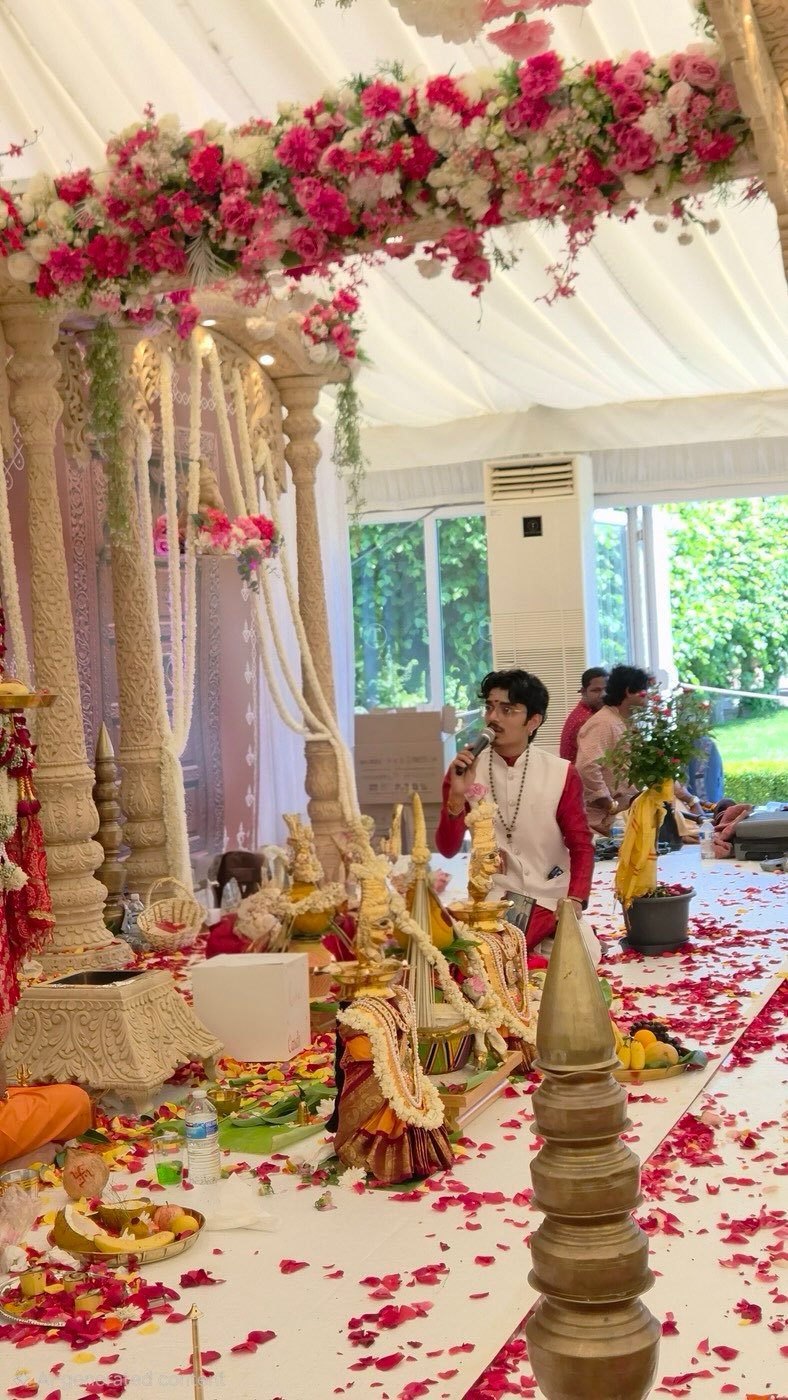 Wedding mandap with red rose garlands and a puja set up below
